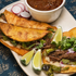 close up platter of tacos with lime and dipping sauce